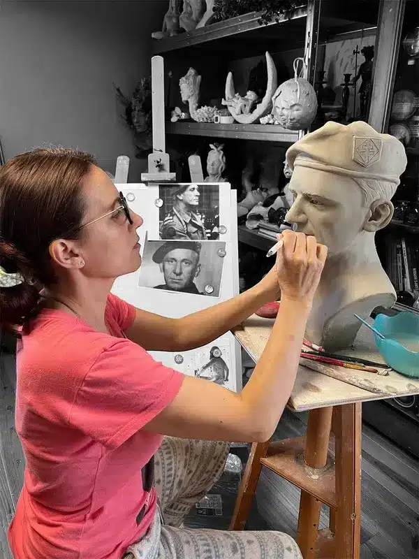 Adèle Lagarde en train de sculpter un buste en terre